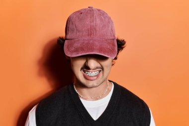 Şık giyinmiş yakışıklı genç bir adam kendine güvenerek duruyor, neşeli bir cazibe yayıyor..