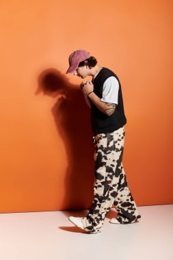 Şık giyinmiş yakışıklı genç bir adam zarif bir şekilde yürüyor, eşsiz tarzını sergiliyor..