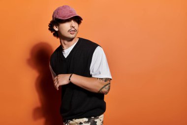 Bu şık genç adam modern moda eğilimlerini kendine güvenerek canlı bir ortamda sergiliyor..