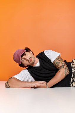 Dövmeli genç adam modern bir ortama güvenerek şık bir şekilde rahatlıyor..