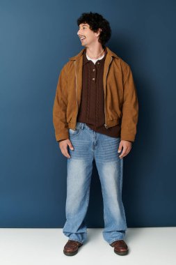 Yakışıklı genç bir adam ayakta dururken kendine güvenen ve çekici modern bir görünüm sergiliyor..