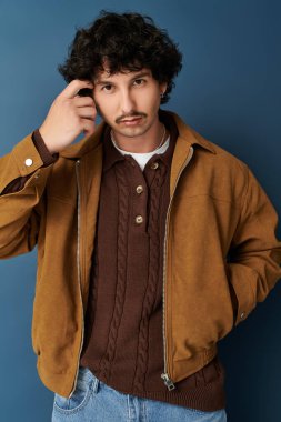 Çekici bir tarzı olan genç adam, içeride şık bir kıyafet giyerken kendine güvenini gösteriyor..