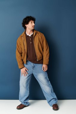 Yakışıklı genç adam kendine güveni tam, modern moda seçimleri sergiliyor ve rahat bir duruş sergiliyor..