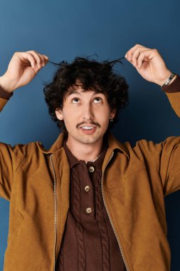 Şık bir genç adam kıvırcık saçlarını içeride düzeltirken neşeli bir anın tadını çıkarır..