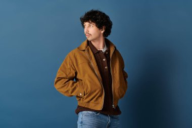 Şık bir genç adam modaya uygun giyinip, kendine güvenerek poz verir..