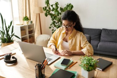 Genç bir Afrikalı Amerikalı kadın özenle modern dairesinde çalışıyor, notlar alıyor..