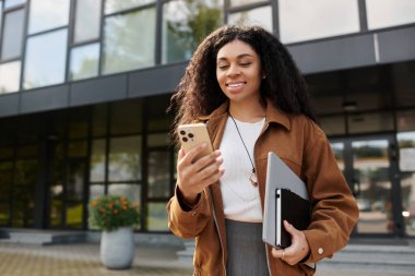 Genç bir Afrikalı Amerikalı kadın, şık bir sonbahar elbisesi içinde dışarıda vakit geçirmekten hoşlanıyor..