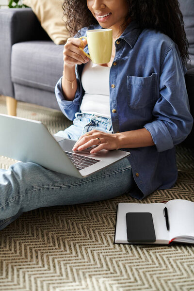 Творческий молодой профессионал занимается фрилансом, расслабляясь дома и потягивая чай.