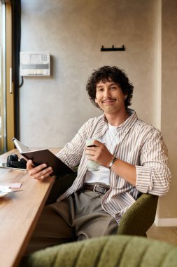 Yakışıklı genç adam bir kafede rahatlıyor, bir içki yudumlarken bir not defteriyle fikirleri yakalıyor..