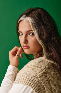 Benzersiz özellikleri olan kendine güvenen bir kadın, güzelliğini zengin yeşil bir arka plana karşı sergiliyor..