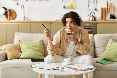Şık bir genç adam hareketli, rahat bir oturma odasında konuşuyor..