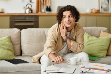 Şık bir iş elbisesi içinde genç bir adam telefonda güvenle konuşur..