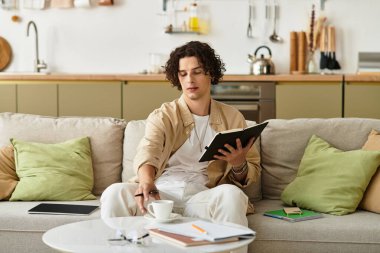 Şık genç adam deftere yazıyor, rahat bir yerde kahve molası veriyor..