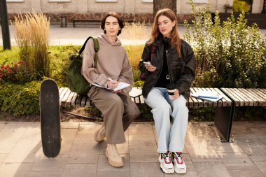 Sevgi dolu çift bir bankta oturuyor, yeşilliklerle çevrili, gülücüklerini ve neşelerini paylaşıyorlar..