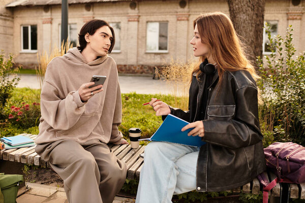 Couple relaxes on a bench in a park, sharing a warm moment with coffee and a notebook.