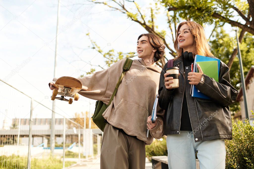 A happy couple strolls casually outdoors, sharing moments of love and laughter with friends.