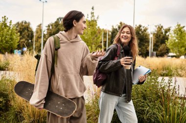 Genç bir çift yeşillik dolu bir parkta yürürken birbirlerine eşlik etmekten zevk alır..