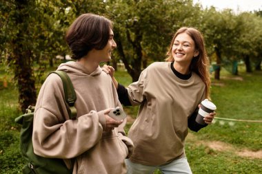 Genç çift, sevgi dolu bir meyve bahçesinde dolaşırken birbirlerine eşlik etmekten hoşlanırlar.