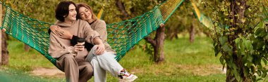 Genç bir çift, yemyeşil bir hamakta birlikte gülüyor..