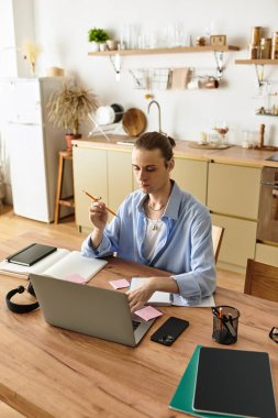 Genç yakışıklı adam, parlak çalışma alanında notlar ve fikirler düzenliyor..