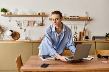 Sıcak dekorla çevrili şık bir mutfak masasında işine odaklanmış genç bir adam..