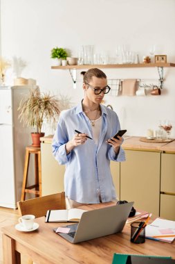 Parlak bir mutfakta, yakışıklı genç bir adam telefon ve not defteriyle görevlerini yerine getirir..