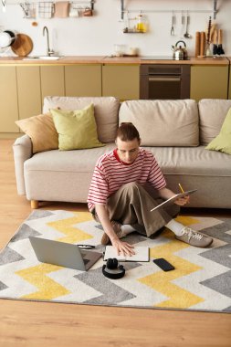 Yakışıklı genç bir adam, sıcak ve canlı bir mutfağın zeminine resim çizer..