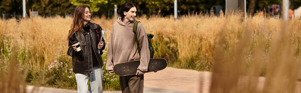 Two young people enjoy a warm moment while walking in a lush outdoor space.
