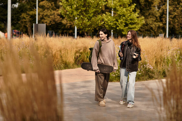 Two young lovers walk happily through a stylish park, soaking in the warm sunlight.