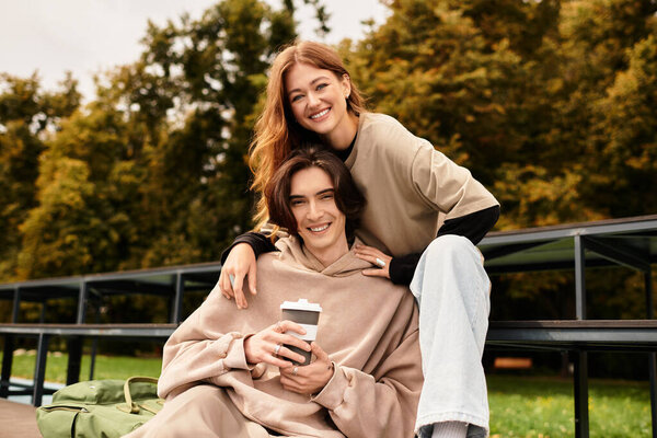 A loving couple enjoys each others company while sitting outside, surrounded by nature.