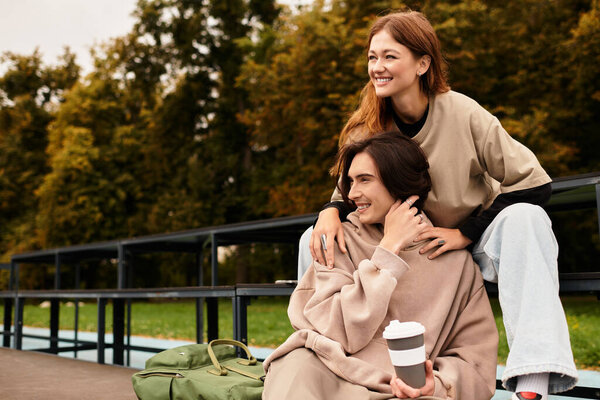 Young couple shares a joyful moment outdoors, surrounded by nature and warm sunshine.