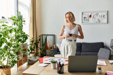 Sıcak ve davetkar bir ev ortamında, bir kadın içkisini yudumlarken yaratıcı zamanının tadını çıkarır..