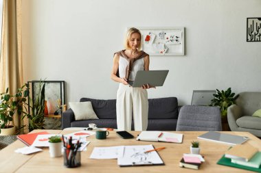 Bir kadın evinde rahatlıyor, laptopuyla yaratıcı bir şekilde çalışıyor..