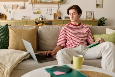 Odaklanmış öğrenci evde rahat bir yaşam alanında dinlenirken e-öğrenim ile ilgilenir..