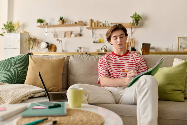 A young man is studying from home, focusing on his online classes in a cozy apartment.