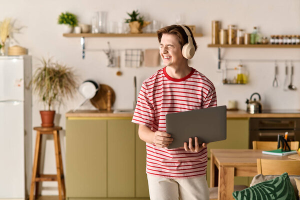 Молодой человек учится дома, наслаждаясь онлайн обучением в своей стильной квартире.