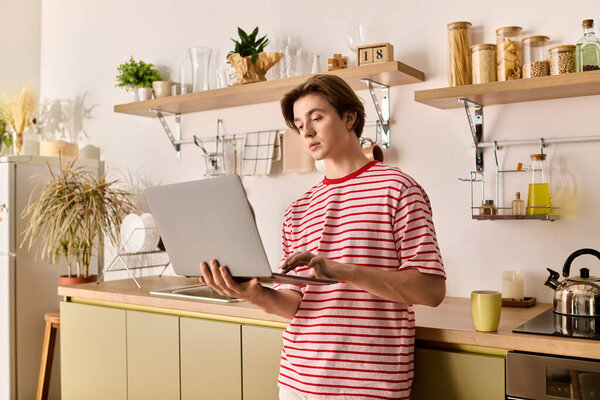 Студент учится на ноутбуке из дома, в окружении стильной кухни и уютного декора.