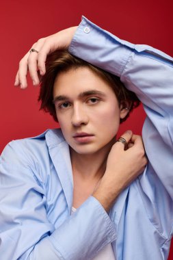 Modaya uygun genç bir adam modern tarzda mavi bir gömlek giyiyor.