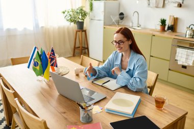 A woman with red hair enthusiastically teaches language lessons online from her home office.