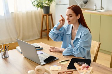 A red-haired woman teaches language lessons online from her cozy home office.
