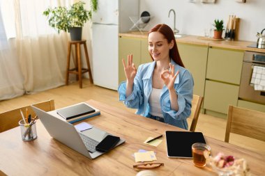 A woman teaches languages remotely with enthusiasm using her laptop at home.