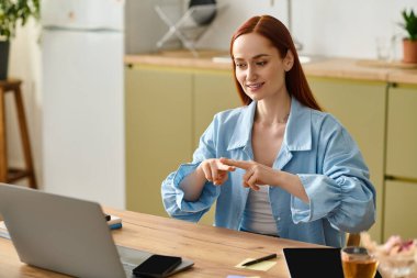 A woman with red hair teaches languages from her home office on a laptop, smiling and attentive.