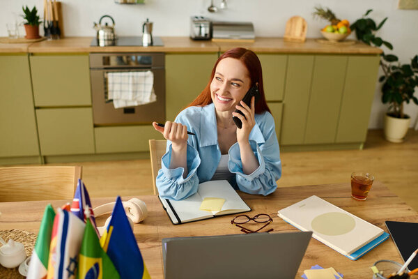 A woman teaches languages online from her cozy home kitchen, using her laptop and phone.