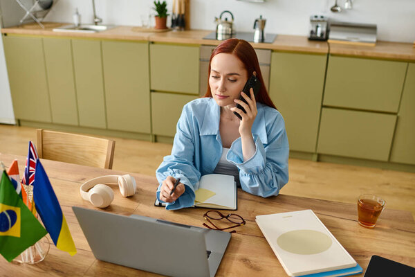 Red-haired language teacher conducts an online class while working from her stylish home office.