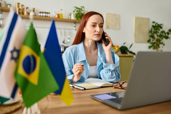 A woman with red hair teaches language online from home using her laptop, while taking notes.