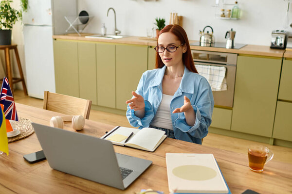 A woman with red hair teaches language skills online, engaging students from her home office.