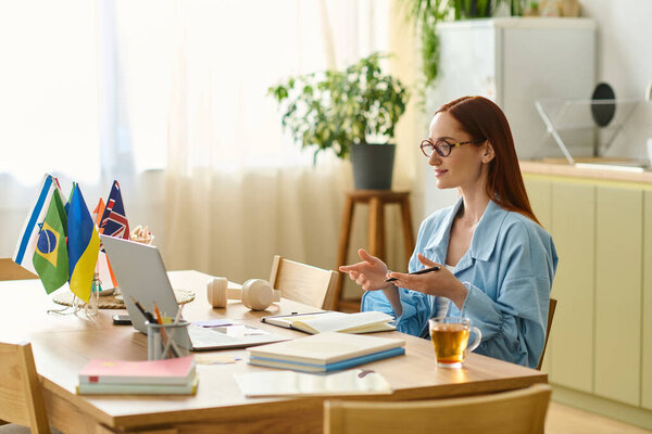 A woman with red hair teaches language lessons online from her inviting home setup with a laptop.
