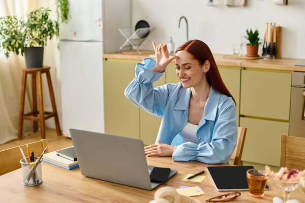 A woman with red hair teaches languages online from her comfortable kitchen workspace.