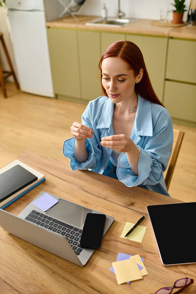 A woman with red hair teaches languages online, working from her comfortable home setup.