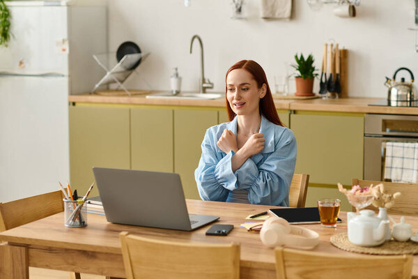 A red-haired woman teaches language classes online from her home workspace.